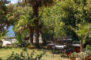 a table and chairs in a garden with plants at Sea View & Beach Luxury Palm Garden Split Apartment in Split