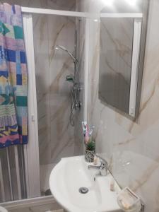 y baño con lavabo y ducha con espejo. en NANNI, en Nápoles