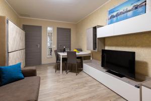 a living room with a television and a dining room at Stella room & apartment in Marsala