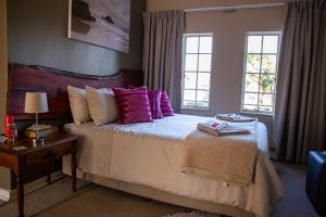 a bedroom with a bed with pink pillows at Ailani Grey in Benoni
