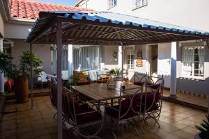 a wooden table and chairs under an umbrella on a patio at Ailani Grey in Benoni