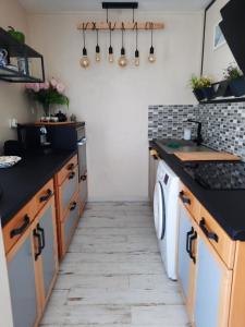 una cocina con encimeras negras, lavadora y secadora en Dune, en La Teste-de-Buch