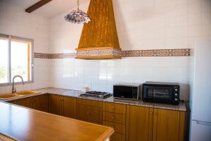 cocina con encimera y microondas en La Casa del Monte, en Les Cases d'Alcanar
