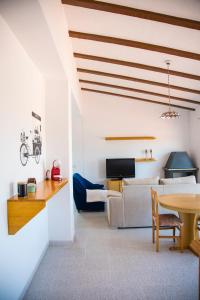 eine Küche und ein Wohnzimmer mit einem Tisch und einem Sofa in der Unterkunft La Casa del Monte in Les Cases d'Alcanar