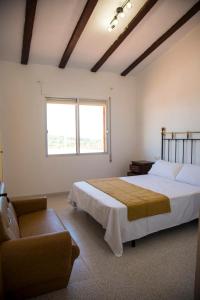 1 dormitorio con 1 cama grande y 1 sofá en La Casa del Monte, en Les Cases d'Alcanar