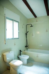 łazienka z toaletą i wanną w obiekcie La Casa del Monte w mieście Les Cases d'Alcanar