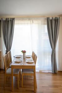 a dining room table with chairs and a window at Modern and Spacious apartments in the City Centre in Sofia