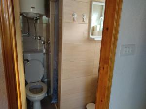 a small bathroom with a toilet and a mirror at Apartments Snowflake in Žabljak