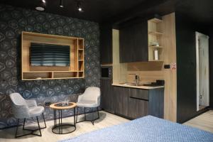 a kitchen with a sink and two chairs and a table at Something Different in Nikšić