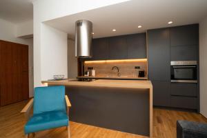 a kitchen with a blue chair and a sink at AthensBlues Glyfada Premium in Athens
