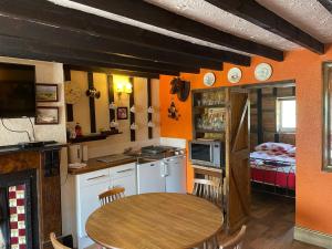 a kitchen with a table and a room with a bed at Yarm cottages the byre in Kirk Leavington