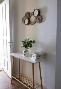a table with books and a plant on a wall at 2ndhomes City Center 2BR Apartment by the Finnish National Theatre with Balcony and Park View in Helsinki