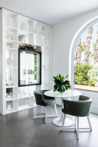 a white dining room with a white table and chairs at Giardino Dei Pini in Alliste