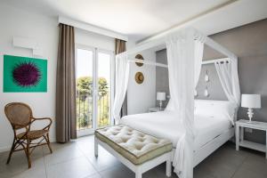 a bedroom with a white canopy bed and a chair at Giardino Dei Pini - Boutique Hotel in Alliste +253 photos