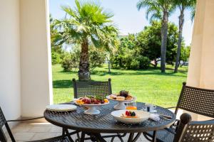 un tavolo con due ciotole di frutta su un patio di Giardino Dei Pini - Boutique Hotel ad Alliste