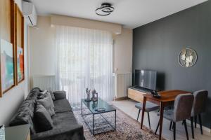uma sala de estar com um sofá e uma mesa em ALEXANDRA Boutique Residence Seaside em Alexandroúpolis