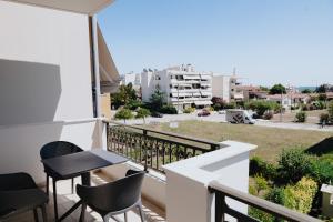 uma varanda com uma mesa e cadeiras e uma vista em ALEXANDRA Boutique Residence Seaside em Alexandroúpolis