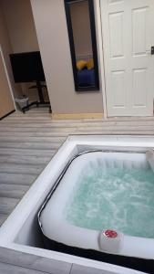 a hot tub in front of a room with a door at Stunning 1-Bed Cabin in Bromley with hot tub in Bromley