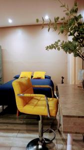 Silla amarilla en una habitación con cama en Stunning 1-Bed Cabin in Bromley with hot tub, en Bromley