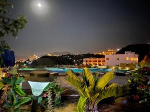 uma vista para uma piscina à noite em La Siesta Hotel Al Sokhna em Ain Sokhna