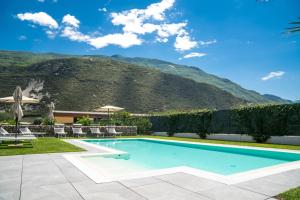 a swimming pool with a mountain in the background at Ca' de L'Olif - Holiday Clima Apartments in Dro