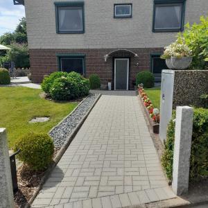 a brick house with a walkway in front of it at Ferienwohnung Heimathafen Westensee in Westensee