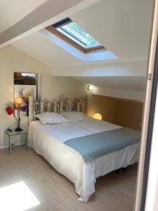 sypialnia z dużym łóżkiem i oknem dachowym w obiekcie Maison de charme avec piscine et jacuzzi dans cadre exceptionnel proche Marseille w mieście Les-Pennes-Mirabeau