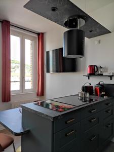 uma cozinha com um balcão preto e uma janela em LE REFLET DES VOILES FACE AU PORT DE FECAMP em Fécamp