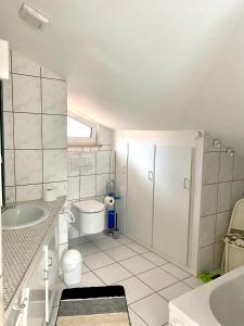 a white bathroom with a sink and a toilet at Möblierte 3 Zimmer Apartment - Mit Smart TV, Wlan und kostenfreie Parkplätze in Schloß Holte-Stukenbrock