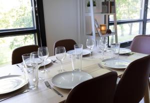 a table with glasses and plates on it at 2ndhomes City Center 2BR Kaisaniemi Park Apartment with Balcony in Helsinki