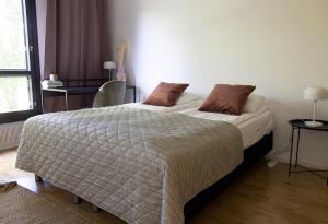 a bedroom with a large white bed with brown pillows at 2ndhomes City Center 2BR Kaisaniemi Park Apartment with Balcony in Helsinki