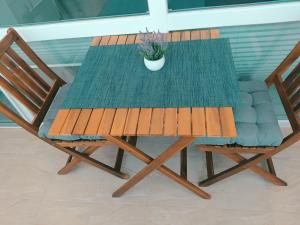 einen Holztisch mit einer Topfpflanze und zwei Stühlen in der Unterkunft Апартамент Blue apartment, гр. Китен in Kiten