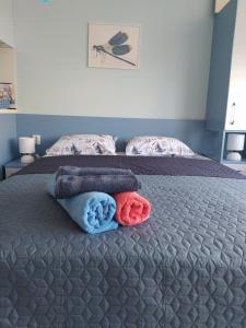 1 dormitorio con 1 cama con toallas en Апартамент Blue apartment, гр. Китен, en Kiten