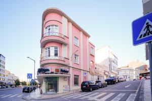 un edificio rosa sul lato di una strada di Duque D`Avila 2 ad Aveiro