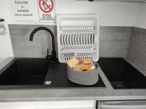 a kitchen counter with a sink with a basket of food at 16 rue des Déportés in Charmes