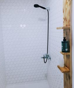 un bagno con doccia e parete bianca di A North Homestay a Omalo