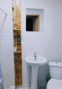 W łazience znajduje się umywalka, toaleta i lustro. w obiekcie A North Homestay w mieście Omalo