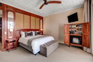 a bedroom with a large bed and a tv at Palm River Hotel in Victoria Falls