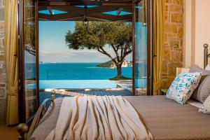 una camera da letto con vista sull'oceano di Kymaros Villas a Keríon