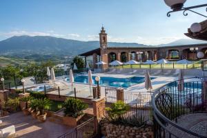 un resort con piscina e torre dell'orologio di Il Poggio ad Ascoli Piceno