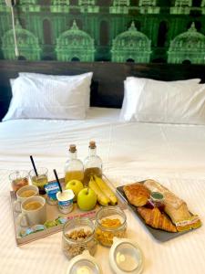 ein Tablett mit Essen und Obst auf dem Bett in der Unterkunft Hôtel Une Chambre en Ville in Toulouse