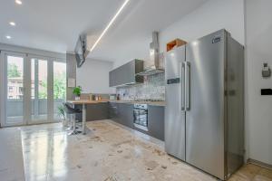 a large kitchen with a stainless steel refrigerator at Alle Porte Del Centro - Guest House - Reggio Emilia - Ingresso Centro Storico - Parcheggio Gratuito in Reggio Emilia