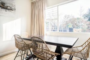 comedor con mesa, sillas y ventana en Avemore Vredehof No 1 - with Backup power, en Stellenbosch