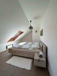 ein Schlafzimmer mit einem Bett in einem weißen Zimmer in der Unterkunft Dedinky Lakeview Cottage in Dedinky