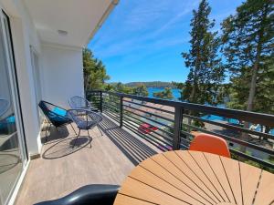 a balcony with a table and chairs and a view of the water at A2D1 Mali Losinj in Mali Lošinj