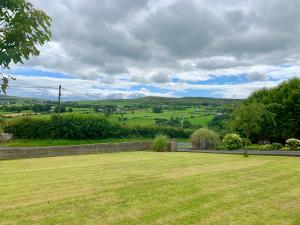 un patio de césped con vistas a las colinas en Glens of Antrim apartment, en The Sheddings