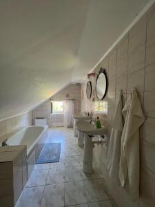 uma casa de banho com 2 lavatórios e uma banheira e um tubermott em Dedinky Lakeview Cottage em Dedinky