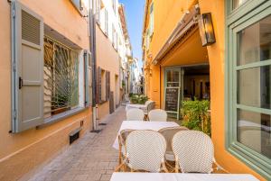 une rangée de tables et de chaises dans une rue dans l'établissement Résidence Feniers - Hyper centre St Tropez, à Saint-Tropez