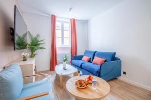 a living room with a blue couch and a table at Résidence Feniers - Hyper centre St Tropez in Saint-Tropez