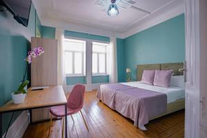 a bedroom with a bed and a table and a desk at Duque D`Avila 2 in Aveiro